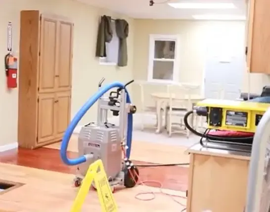 Truck-mounted extraction hose and a wet floor sign in a finished room during water removal