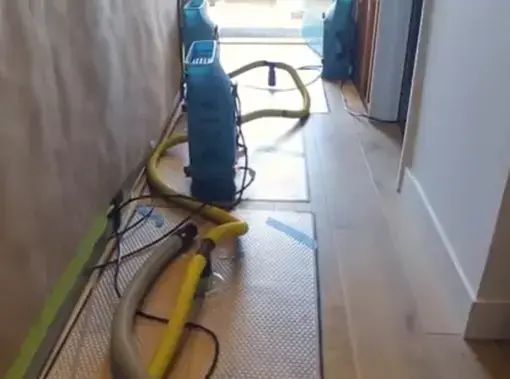 A dehumidifier and hoses set up in a hallway during an Anoka dry-out