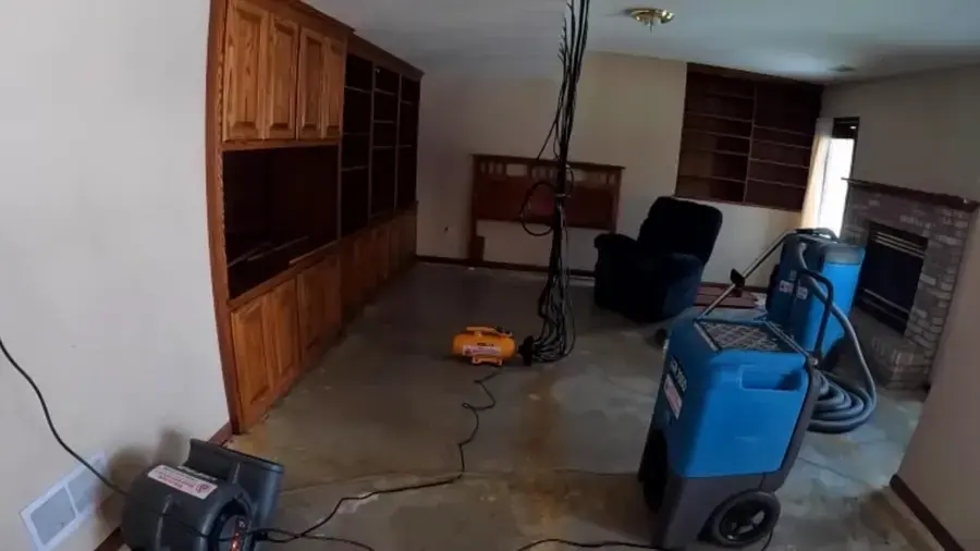 Dehumidifiers and air movers drying a living room down to the bare floor, structural drying in Anoka